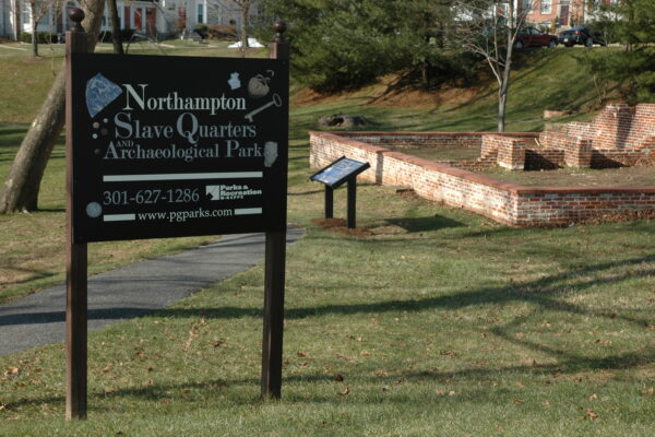 Behind a brown wooden sign that reads